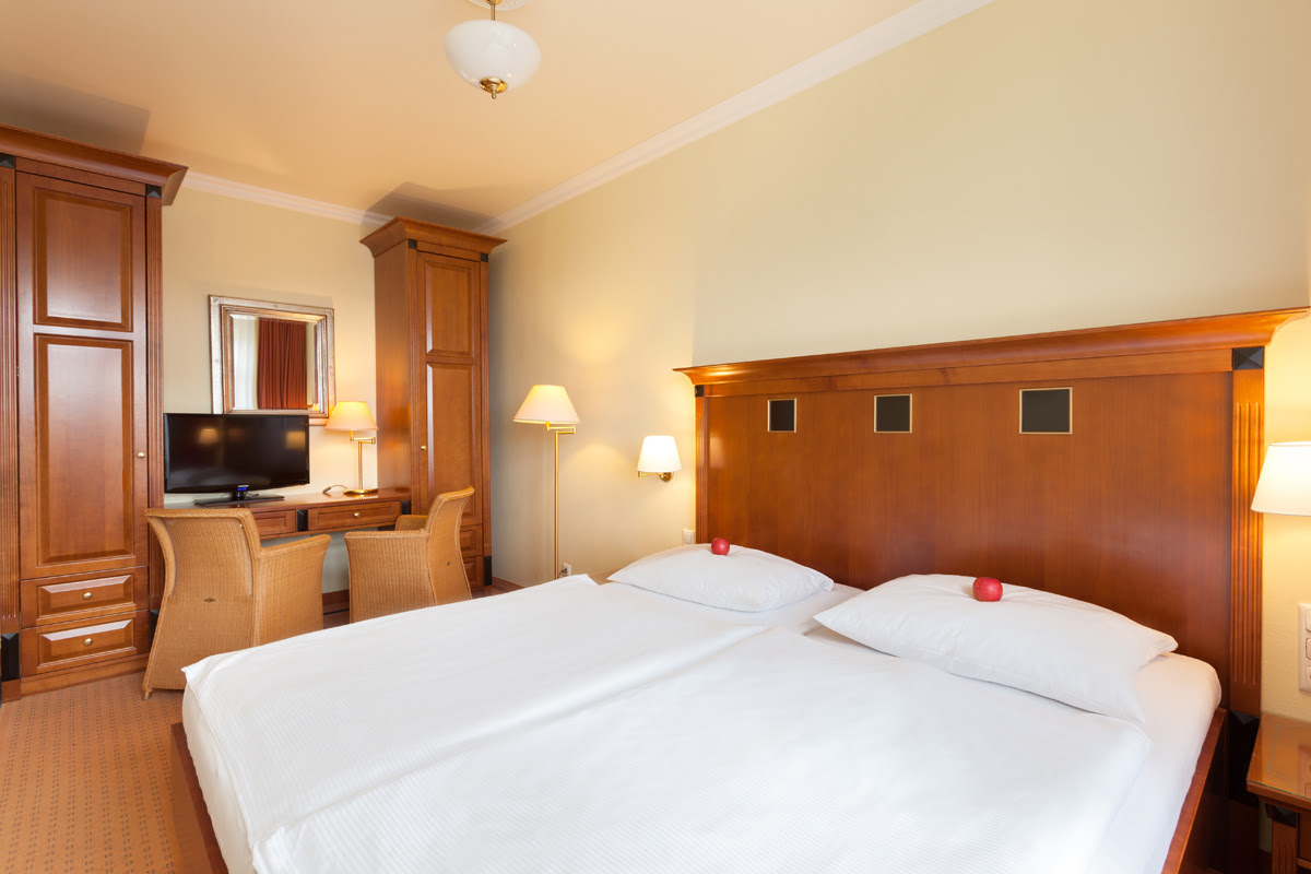 Doppelzimmer in den Dependancen mit großem Doppelbett, stilvollen Holzmöbeln, Schreibtisch und TV im Vju Hotel.