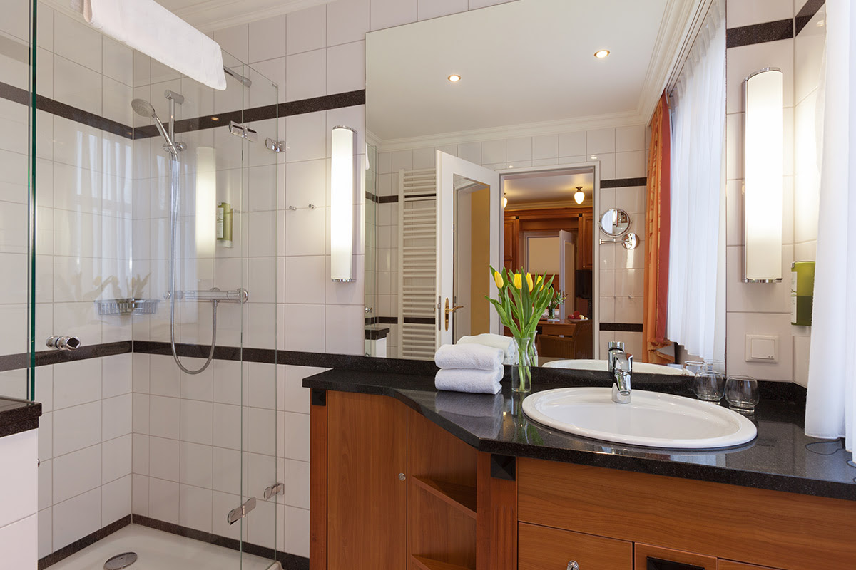 Comfortable bathroom with rain shower, elegant washbasin and high-quality fittings in the double room at the Vju Hotel.