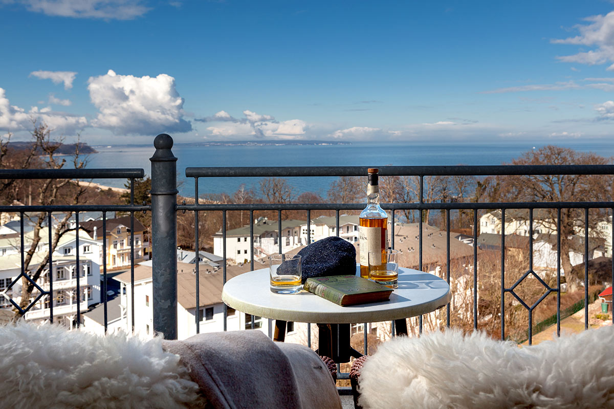 Cozy balcony with sea view, fluffy blankets and a table for relaxing moments at the Vju Hotel.