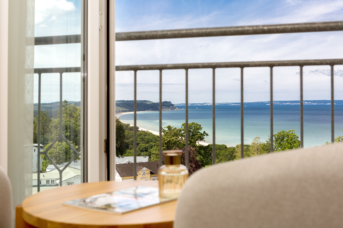 Gemütlicher Balkon des Doppelzimmers im Vju Hotel mit Panorama-Aussicht auf das Meer und die Küste von Rügen.
