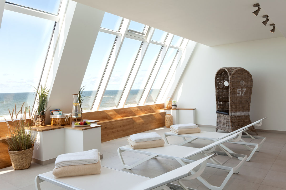 Wellnessbereich im Wyn. Strandhotel mit Liegen, Korbsessel und Meerblick mit zahlreichen Urlaubsangeboten.