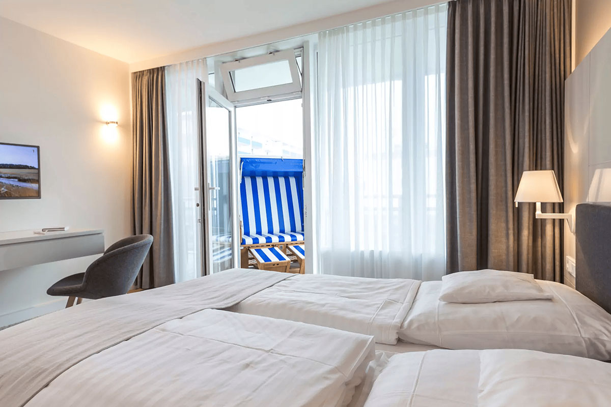 Überblick der Suite Strandhafer mit Doppelbett, Balkonzugang und Strandkorb im Wyn. Strandhotel auf Sylt.