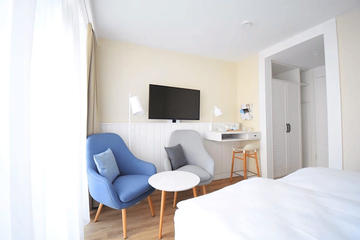 Einladender Sitzbereich mit gemütlichen Sesseln für einen erholsamen Aufenthalt im Zimmer Westerland des Wyn. Strandhotels.