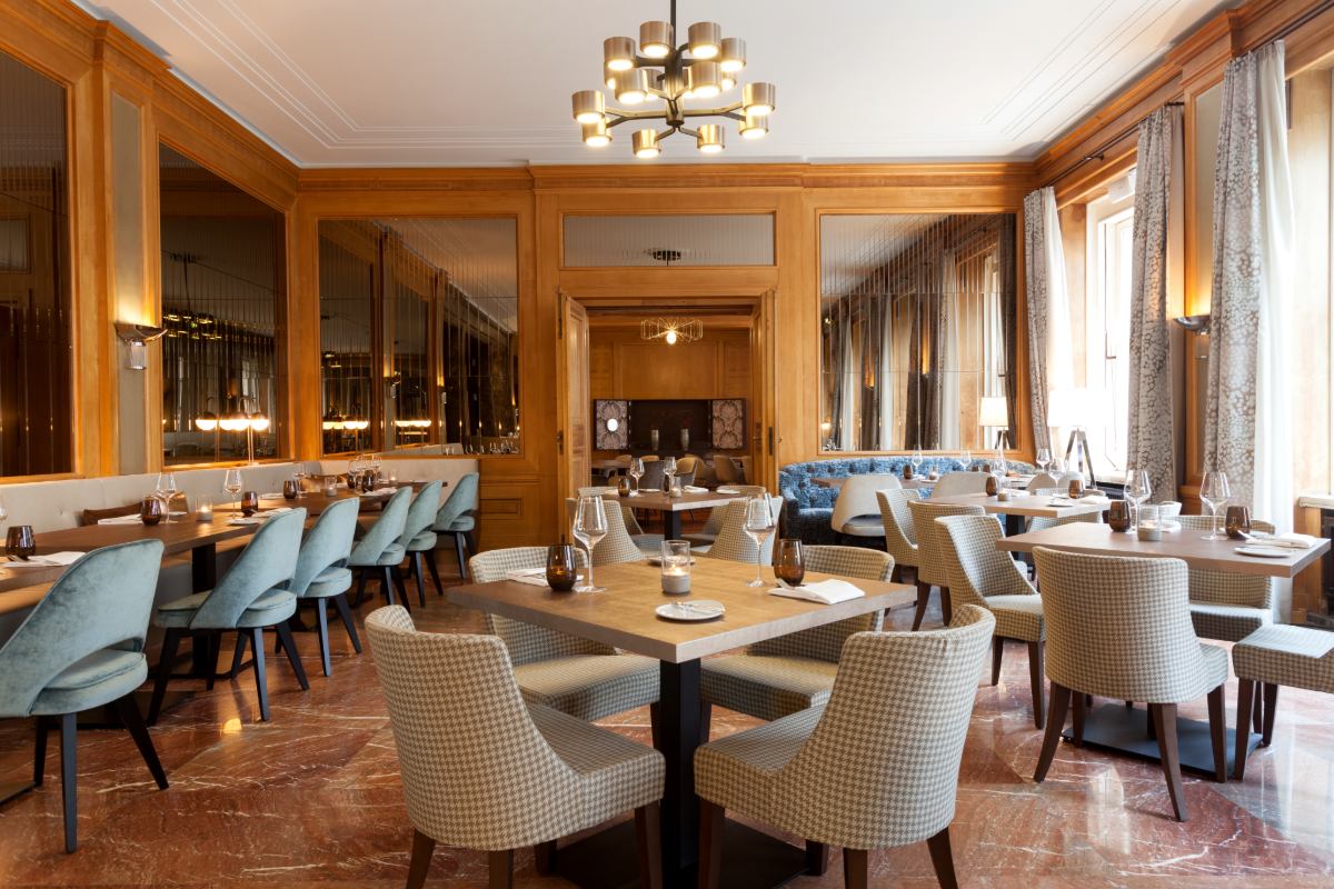 Blick in das elegante Restaurant Anna mit hellen Sesseln, Holzdekor und eingedeckten Tischen im Hotel Elephant in Weimar.