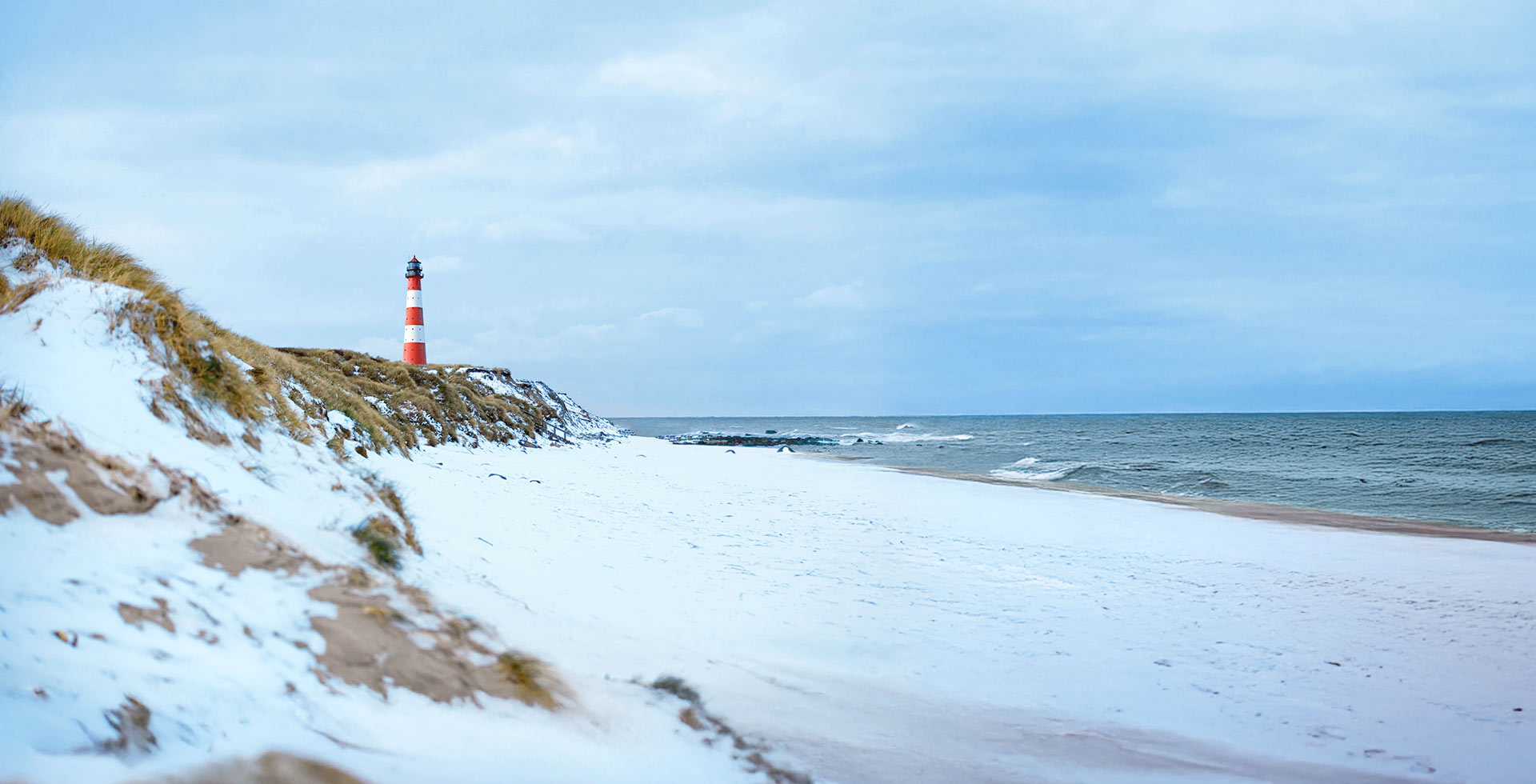 Der einsame Hörnumer Leuchtturm am verschneiten Strand – Winterurlaub mal anders.