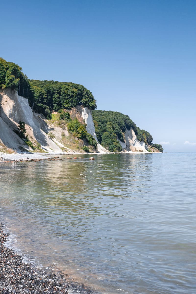Kreidefelsen auf Rügen mit ruhigem Meer und klarem Himmel.