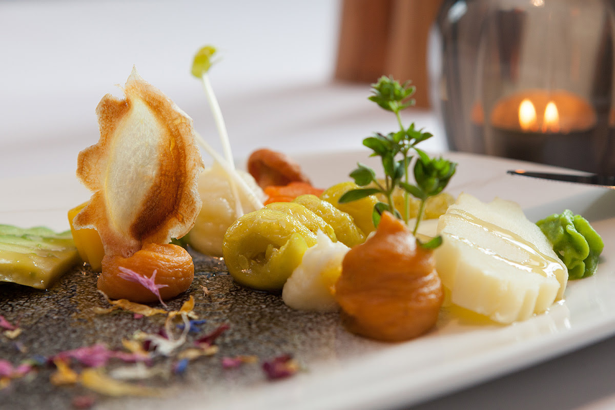 Detailed close-up of an artfully arranged gourmet plate with different textures and colors.