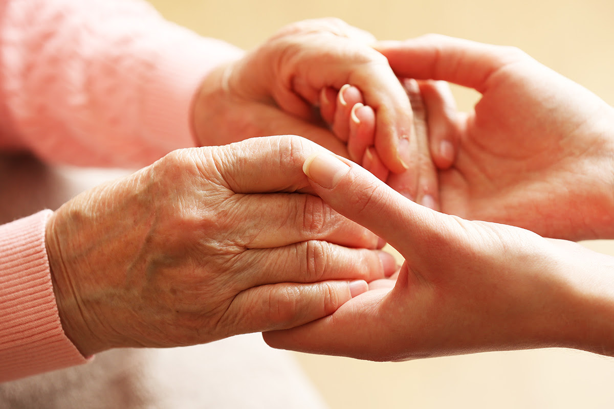 Close-up of two hands holding each other, symbolic of help and support.