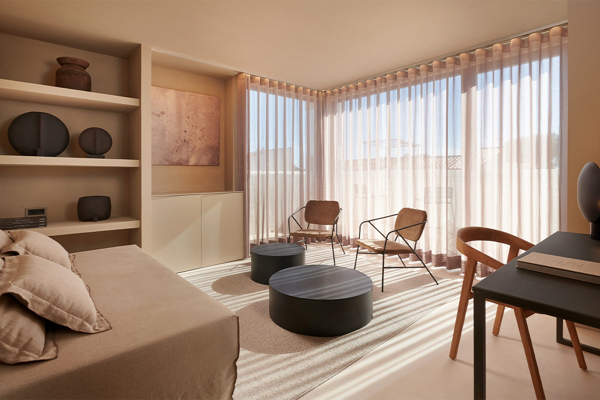 Modernly furnished living room with large windows, soft light and minimalist furniture in the Barefoot Hotel Mallorca.