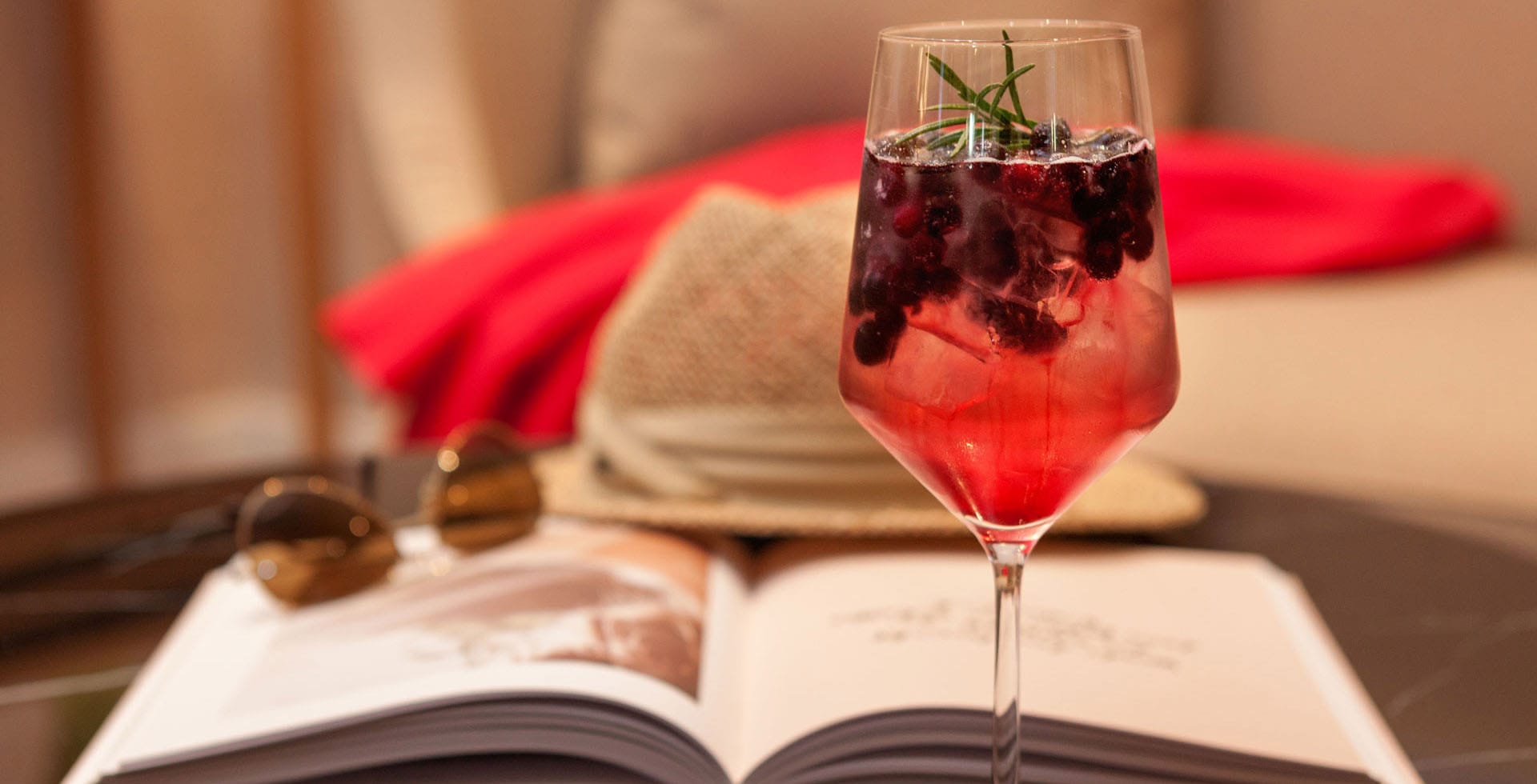 Fruchtiger Cocktail in einem Weinglas in der gemütlichen Lounge Wohnzimmer im Vju Hotel auf Rügen.