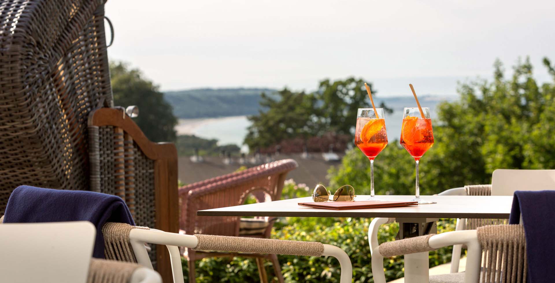 Erfrischende Aperitifs auf der Seeblick-Terrasse des Vju Hotels mit Strandkörben zum Entspannen und weitem Blick auf die Ostsee.