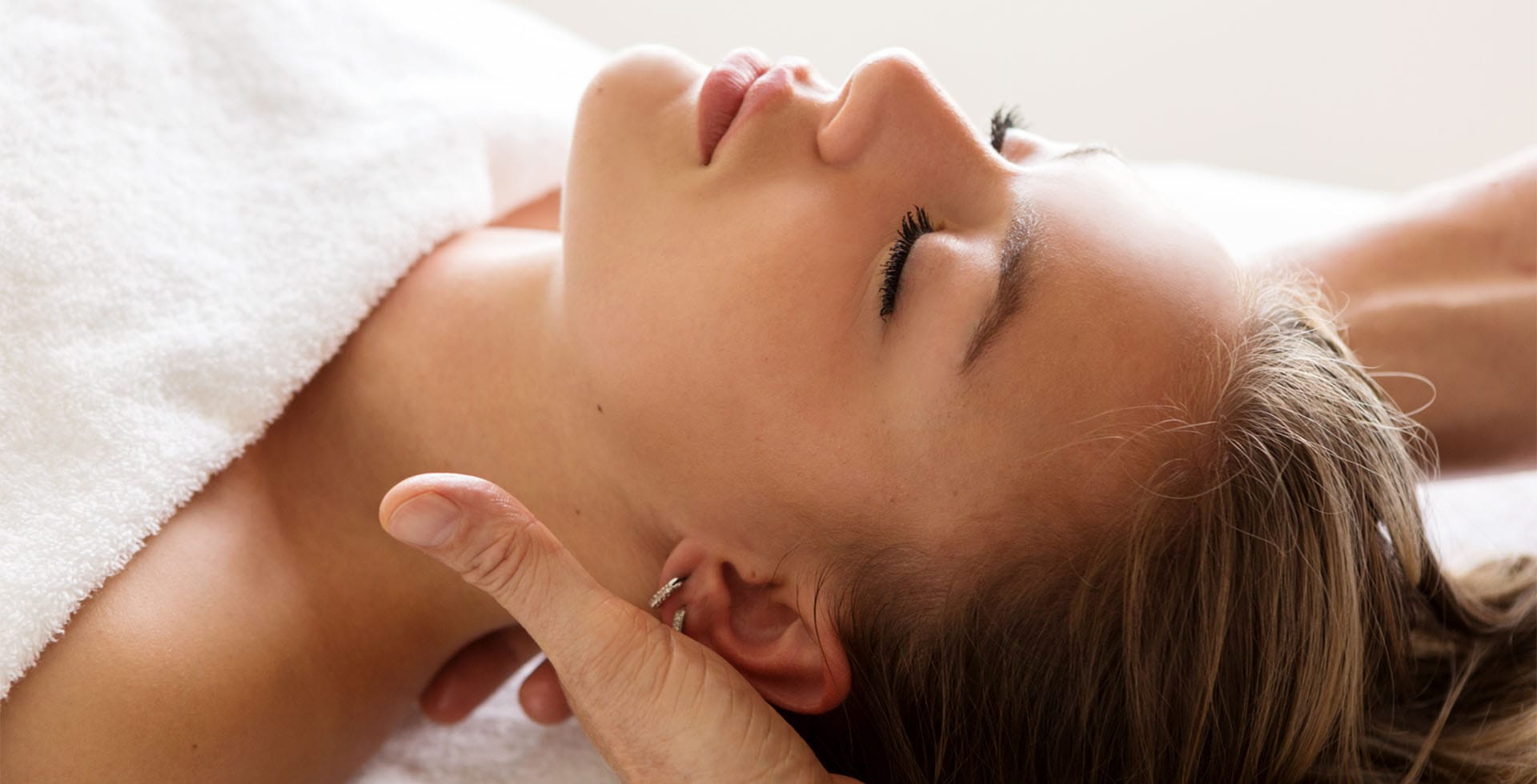 Frau genießt eine entspannende Massage im Wellnessbereich des Vju Hotels auf Rügen, umgeben von einer ruhigen Atmosphäre.