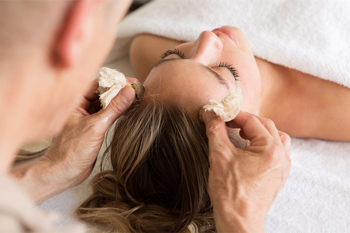 Nahaufnahme einer Wellnessbehandlung im Vju Hotel auf Rügen, eine Frau entspannt sich bei einer Gesichtsmassage.