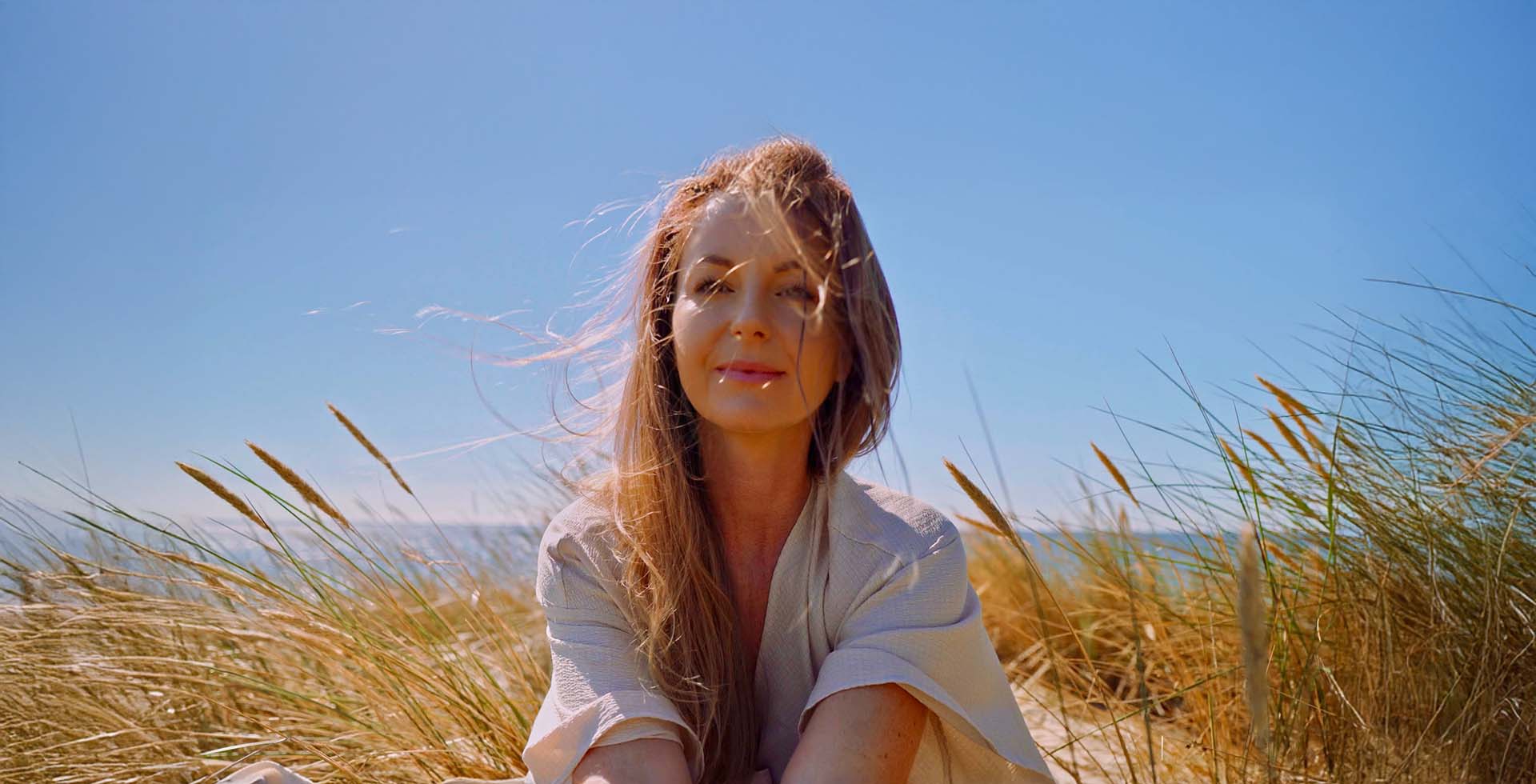 Eine junge Frau mit offenen Haaren am Strand der Insel Rügen