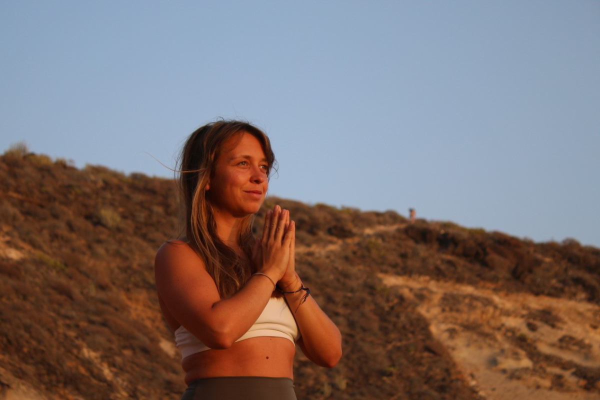 Yoga-Lehrerin Linda Hoffmann praktiziert eine meditative Pose im warmen Abendlicht beim Yoga Retreat im Vju Hotel.