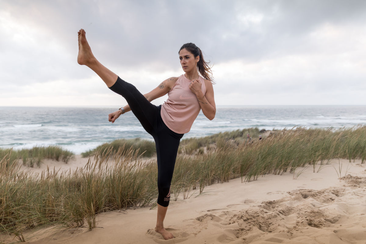 Frau in Yoga-Pose am Ostseestrand mit Blick auf das Meer beim Yoga Retreat im Vju Hotel auf Rügen.