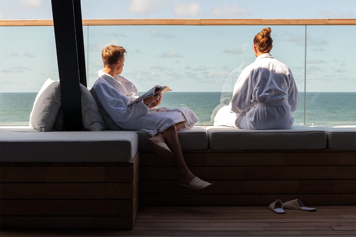 Wellnessbereich im Wyn. Strandhotel auf Sylt mit Panoramafenstern, Sitzgelegenheiten und entspannter Atmosphäre.